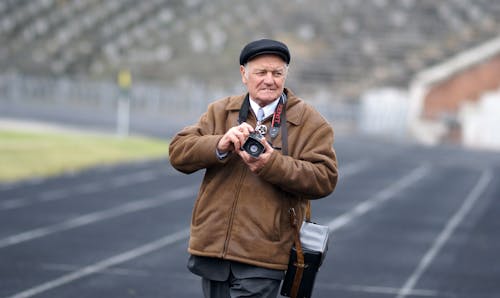 An older man is taking a picture on a track