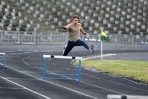 A man jumping over a hurdle on a track
