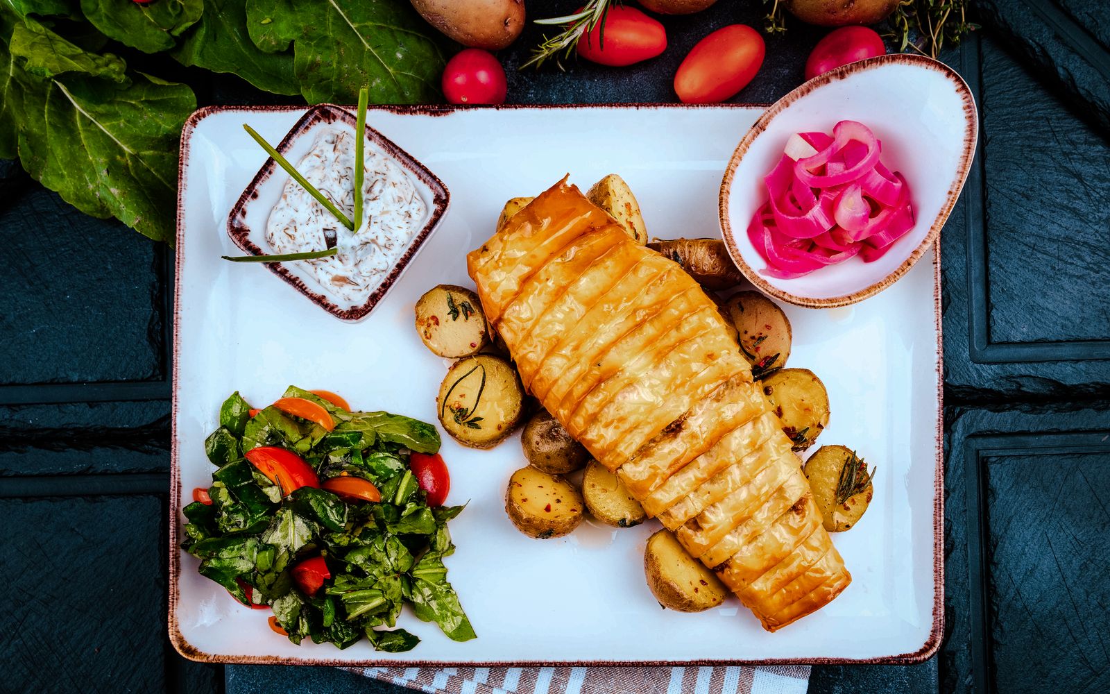 Foto de Tilápia assada com tomate, ervas e batatas