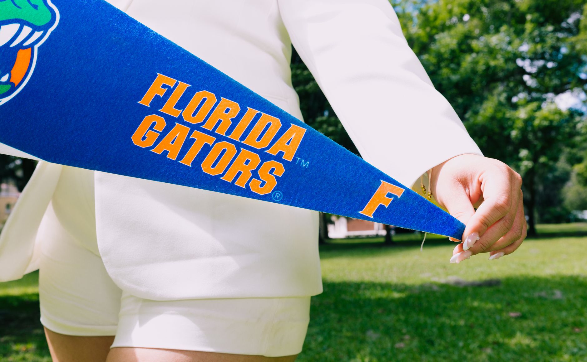 Fashionable woman holding a Florida Gators pennant outdoors in summer. — Prairie View A&M in Florida