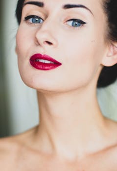 Close-up portrait of a woman with striking red lips and captivating blue eyes, showcasing beauty and elegance.