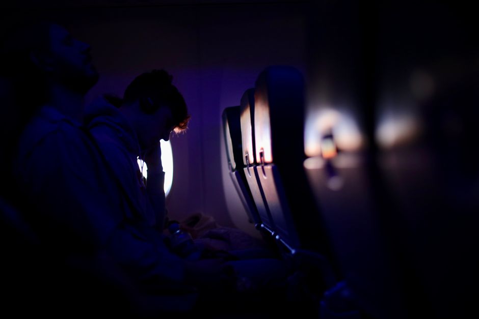Passengers resting in a dim airplane cabin