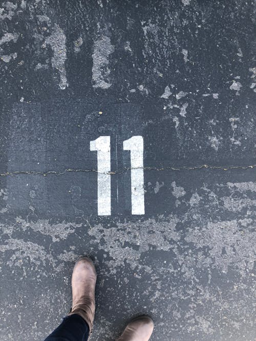 숫자 11 페인트로 콘크리트 바닥에 서있는 사람