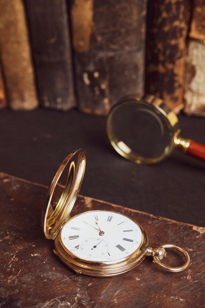 Gold pocket watch beside a magnifying glass, photo by Саша Алалыкин on Pexels
