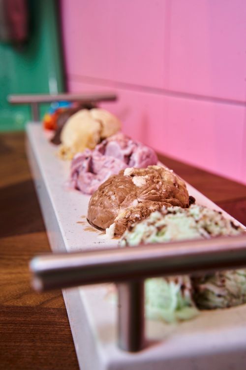 Free Colorful assortment of different ice cream scoops on a wooden tray with a pink background. Stock Photo
