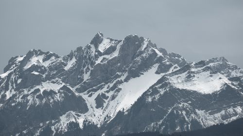 Free Stunning view of a snow-covered mountain peak under a gray sky, evoking a sense of tranquility. Stock Photo