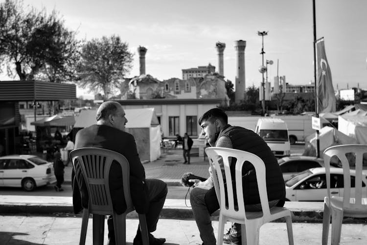 Men Sitting On Chairs And Talking