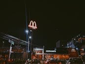 城市中灯火通明的麦当劳餐厅，在夜间展示着霓虹灯标牌