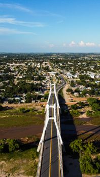 Stunning aerial view of a bridge in Córdoba, Argentina with a sprawling cityscape under a bright blue sky.