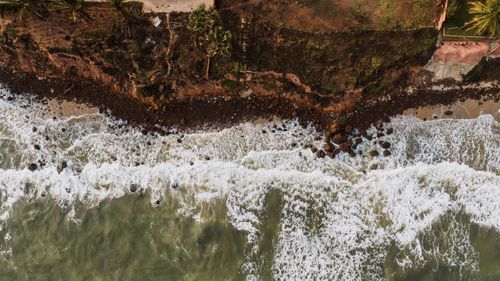 Free Drone shot capturing a dramatic view of ocean waves hitting a rocky coastline. Stock Photo