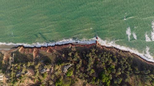 Free Aerial photograph showcasing dramatic cliffs and ocean waves along a rugged coastline. Stock Photo