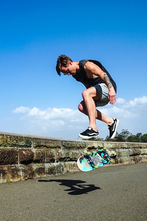 Free Jumping Man Together With Blue Skateboard Stock Photo