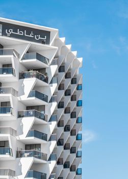 A modern architectural residential building in Dubai featuring geometric designs under a clear blue sky.