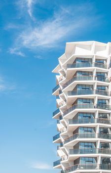 Contemporary architectural design of a luxury apartment building in Dubai, under a bright blue sky.