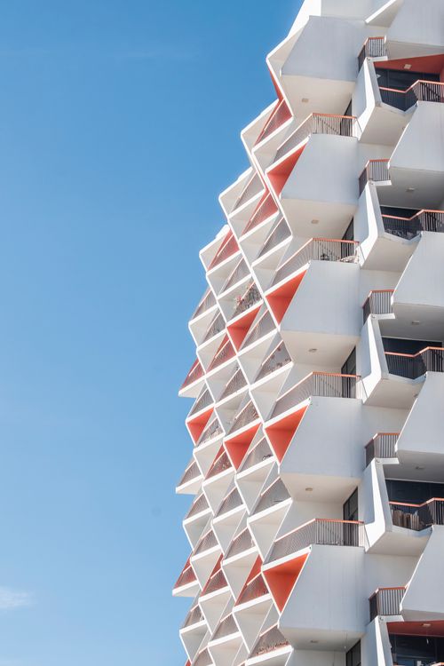Free Architectural detail of geometric balconies against a clear blue sky in Dubai. Stock Photo
