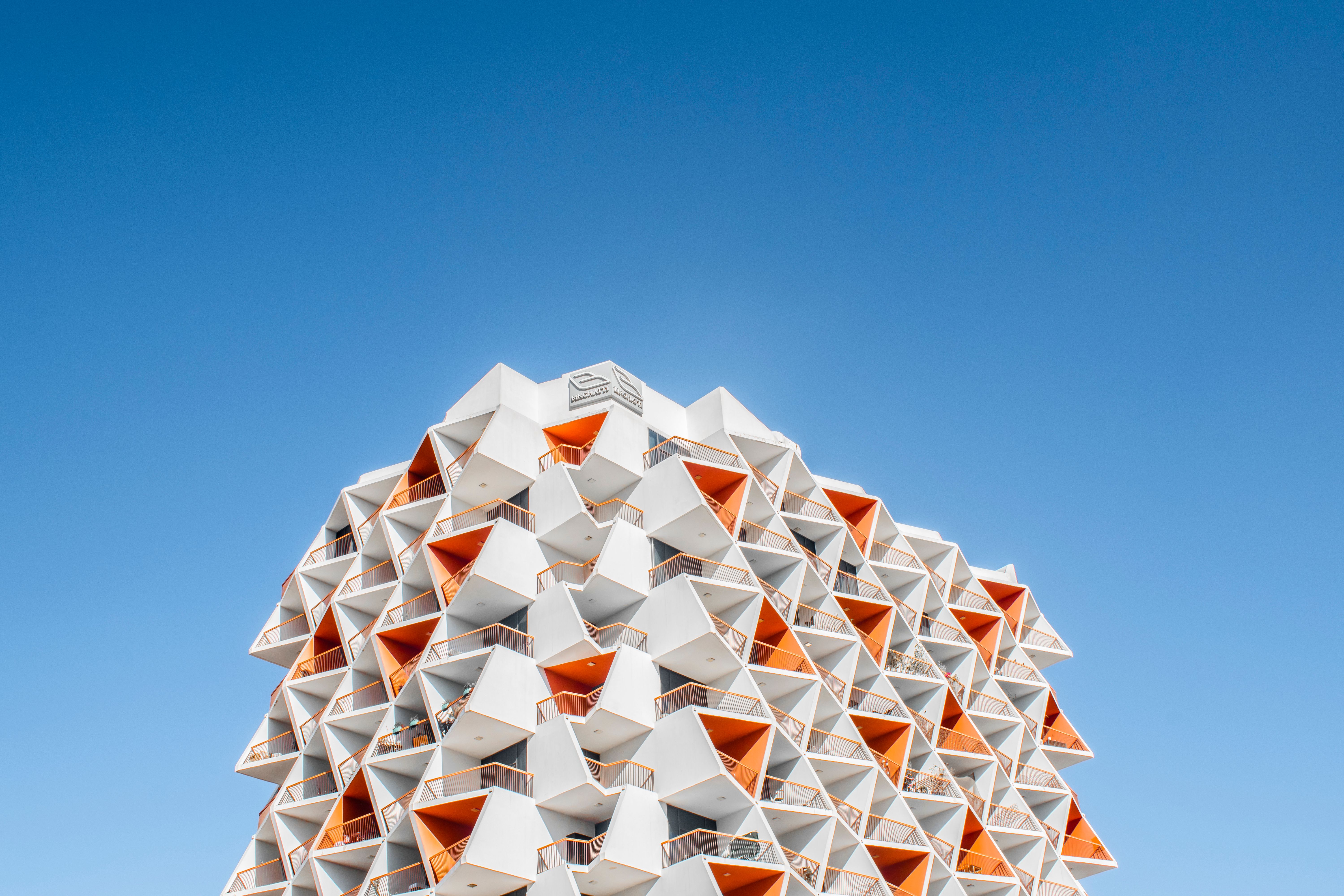 A stunning geometric architectural design against a vibrant blue sky in Dubai.