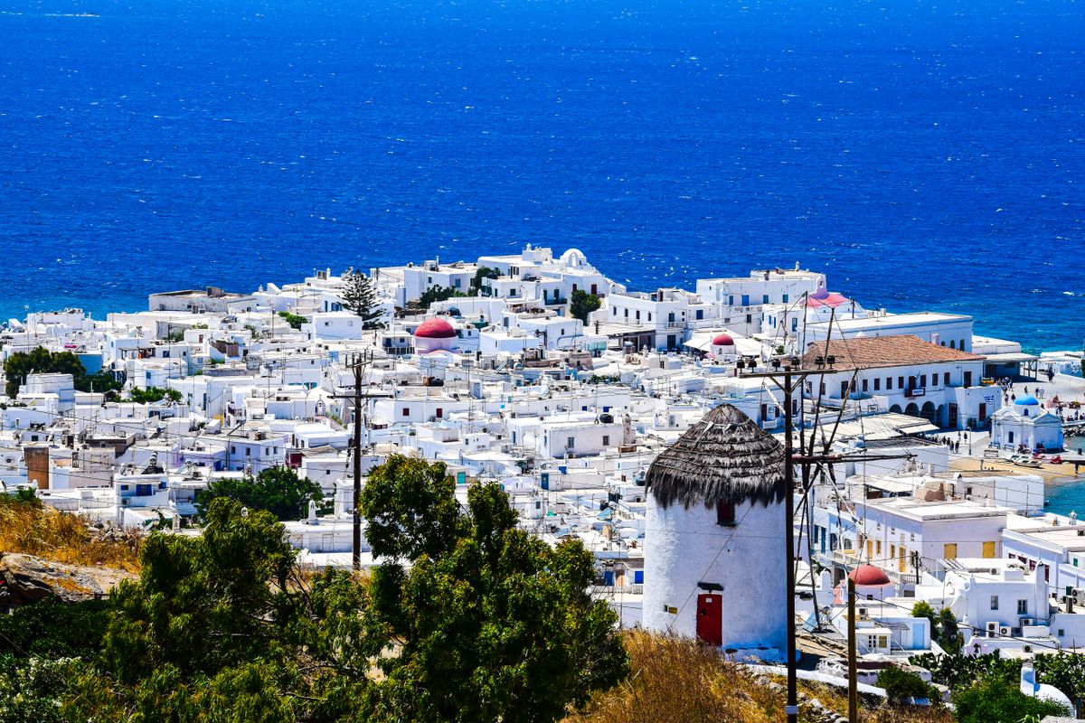 Whitewashed Mykonos Town (Chora) with a windmill above the Aegean Sea