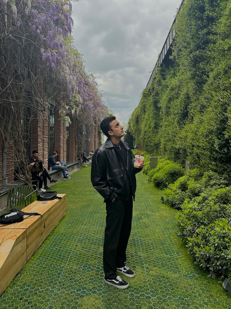 Young Man In A Park Holding A Cup Of Coffee 