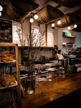 Warm and inviting coffee shop interior featuring rustic wooden counter and ambient lighting.