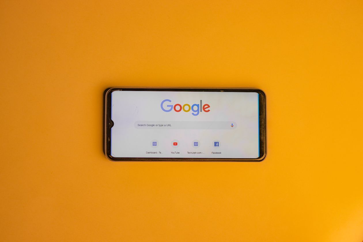 Smartphone displaying a search engine page against a bright yellow background