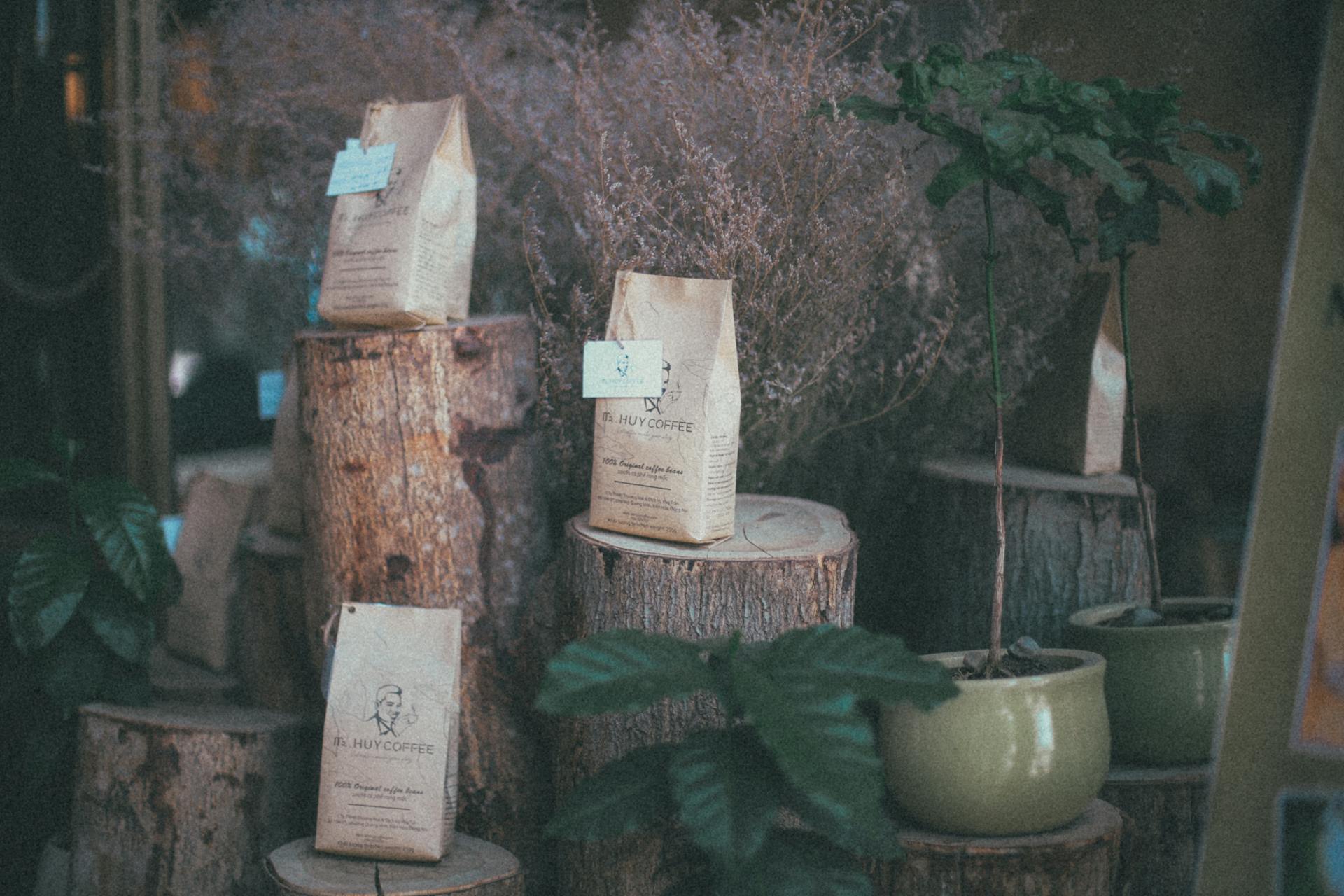 Charming rustic coffee bags displayed on wood logs with vintage touch and greenery.