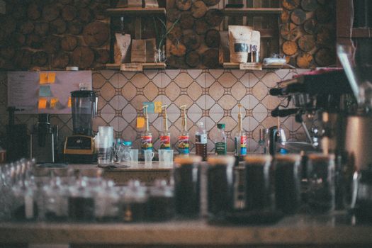 Warm and inviting coffee shop interior with beverage supplies on a rustic counter.