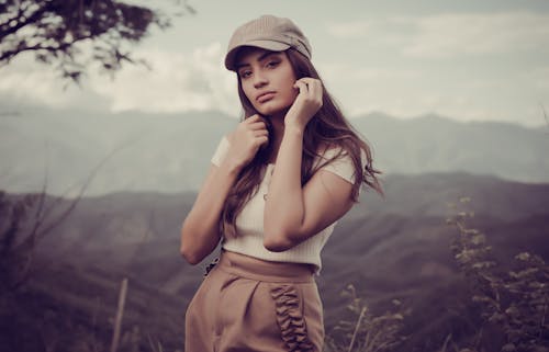 Foto profissional grátis de boné, cabelo castanho, cabelo comprido