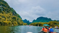 在风景优美、宁静的河流上，人们乘船游览，周围环绕着郁郁葱葱的山脉