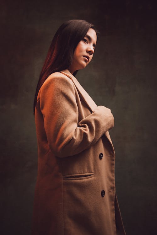 Young Brunette in a Coat Posing in Studio 