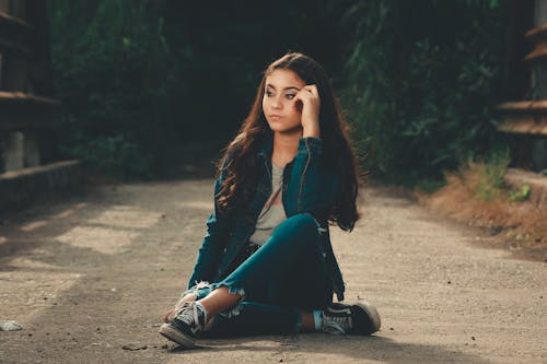 Young Brunette Sitting on the Ground 