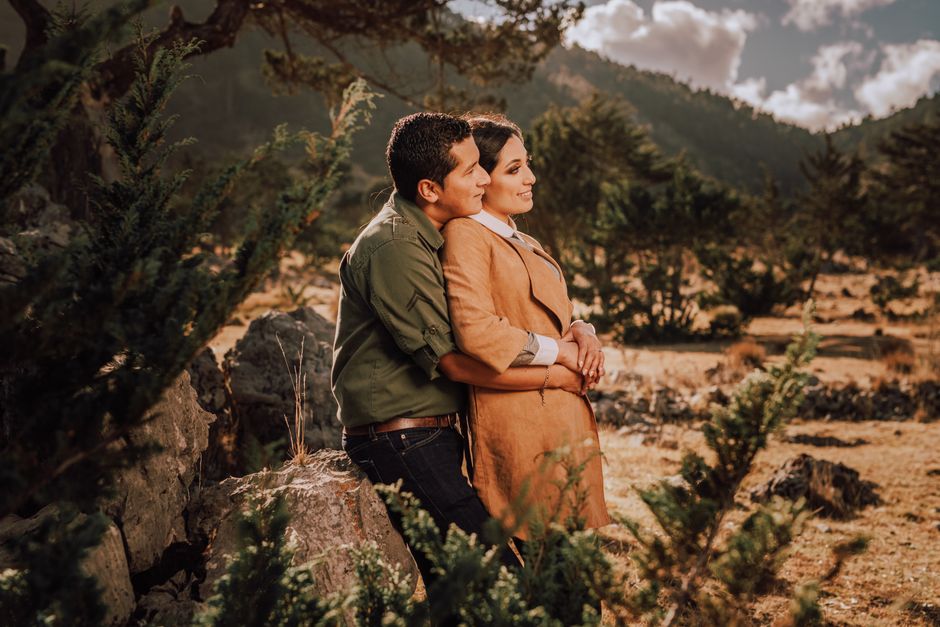 Fotomural Pareja abrazándose en un paisaje otoñal con luz solar cálida.