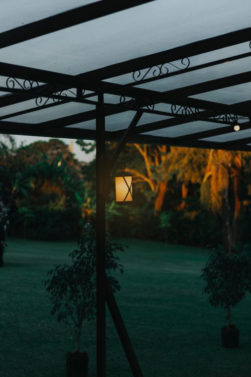 Free A tranquil garden setting in Itu, Brazil, featuring an illuminated lantern at dusk. Stock Photo