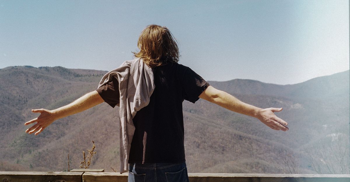 A man joyfully embraces the view of Asheville mountains, symbolizing freedom.