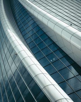 Abstract view of a sleek, modern glass building facade with a futuristic design.