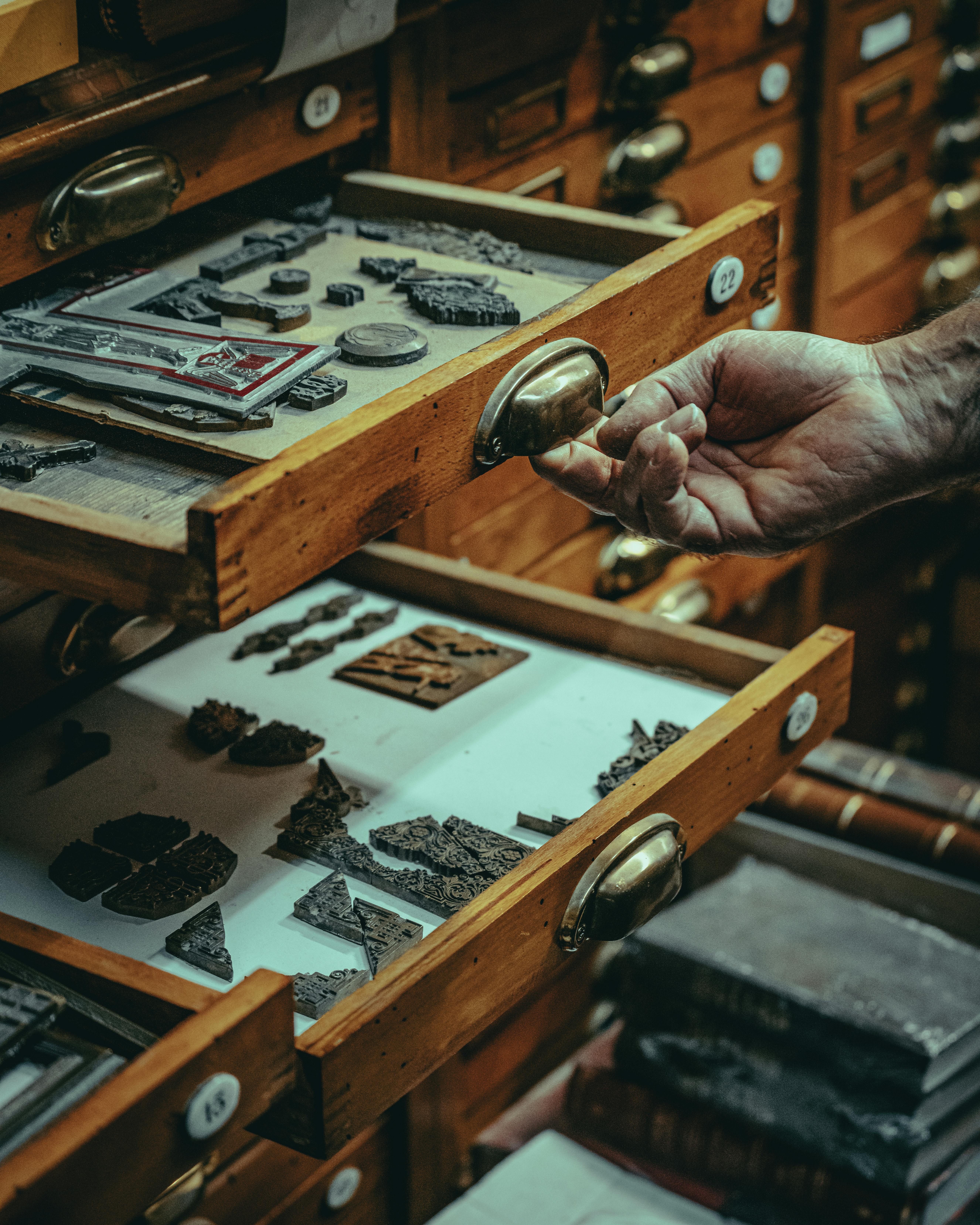Explore vintage printing artifacts in a wooden drawer, showcasing a glimpse of history and craftsmanship.