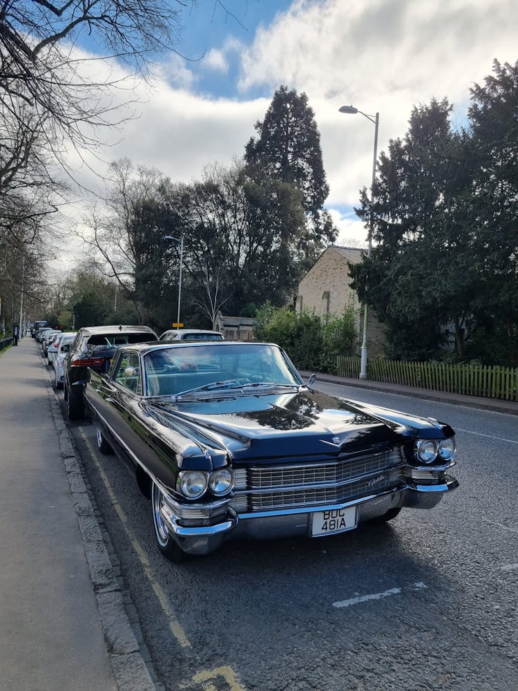 Black Vintage Cadillac Coupe De Ville Car Parked On A Quiet Suburban Street