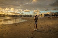 一个人在宁静的海滩上捕捉日落，营造出温暖而宁静的氛围