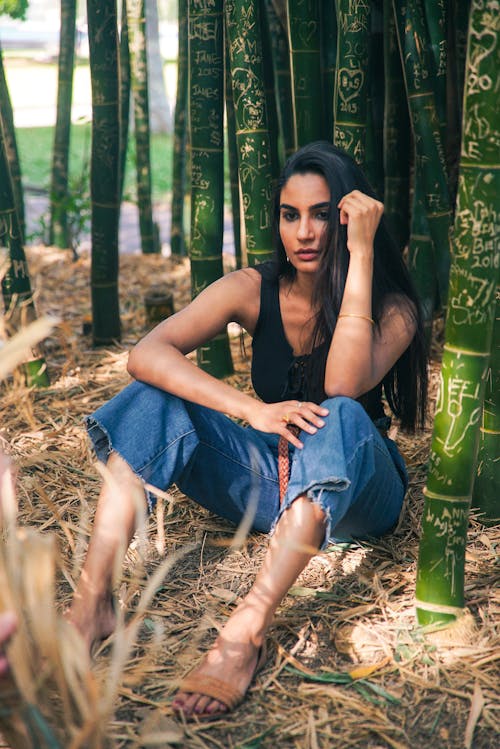 Frau Sitzt In Der Nähe Von Bambus