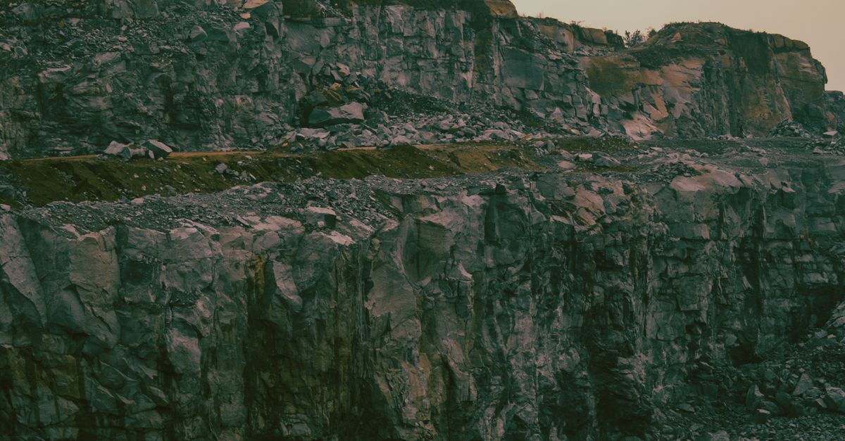 Photo by General Kenobi Stunning image of steep, eroded rock formations in a quarry at dusk.