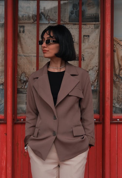 Free Young Brunette Wearing Sunglasses and Standing in front of the Door  Stock Photo