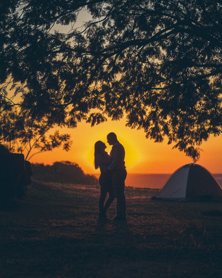 Man And Woman By Tent At Golden Sunset