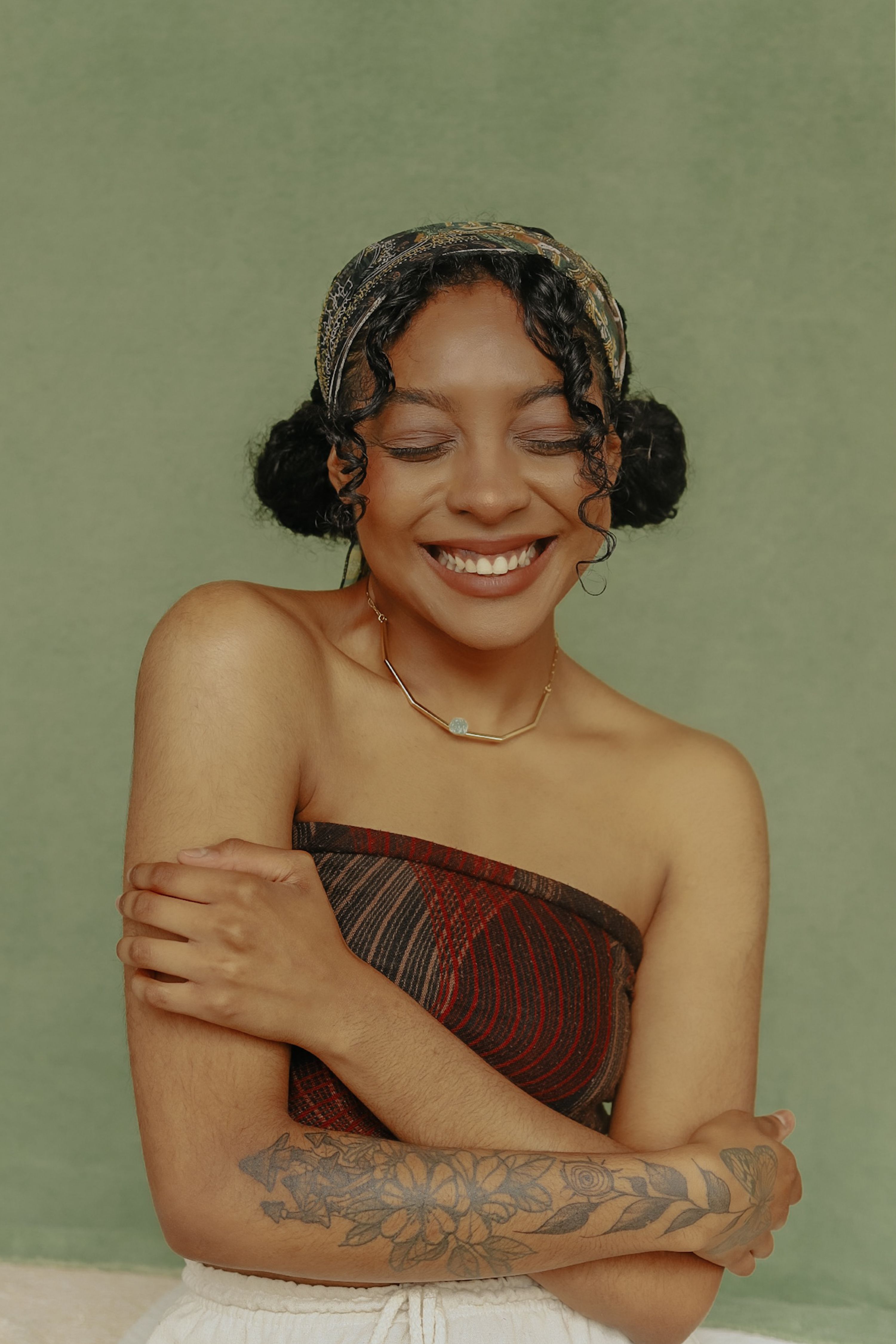 Smiling woman with a stylish tattoo and off-shoulder top, exuding warmth and style in São Paulo, Brazil.