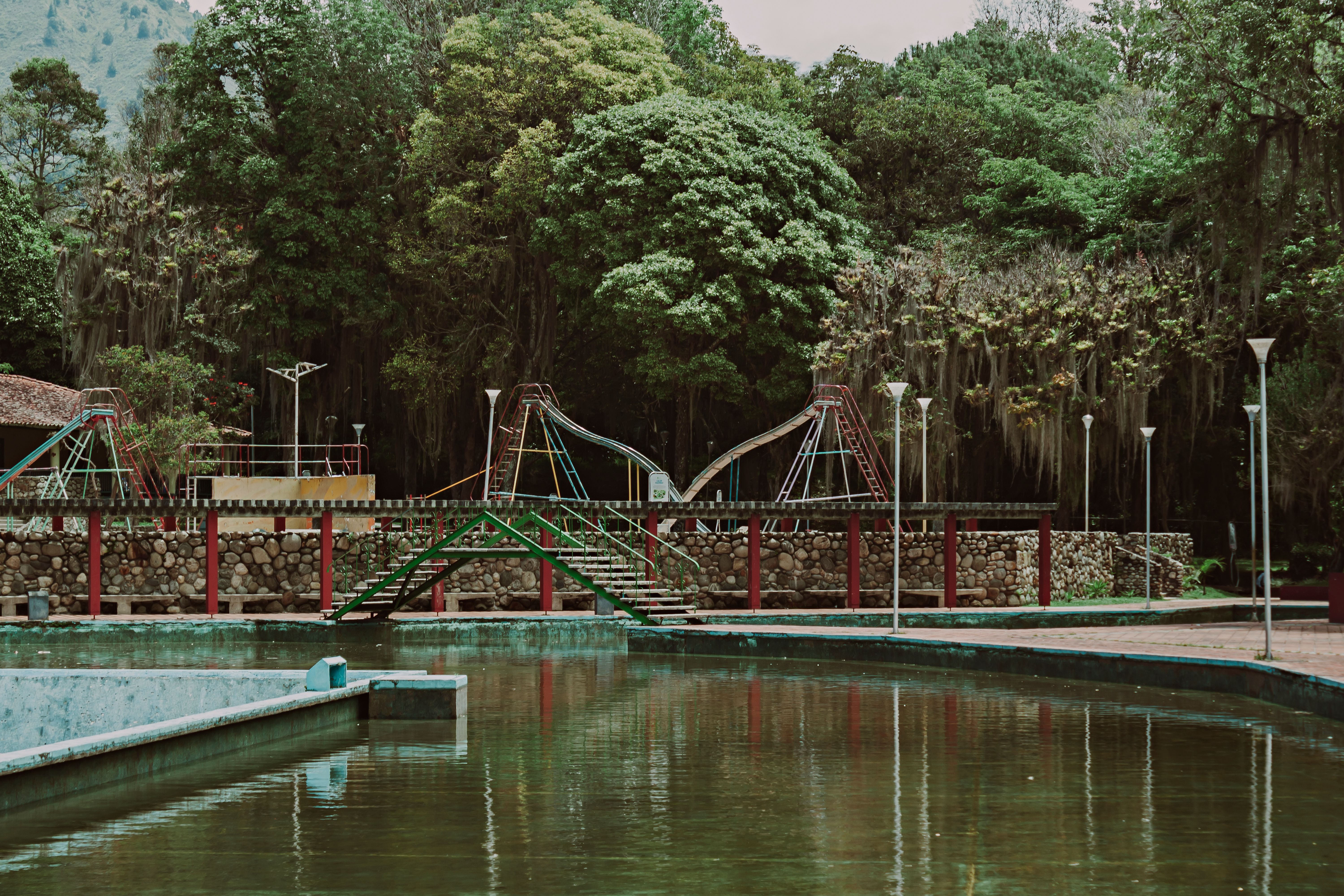 Fotomural Vista serena de un parque con árboles y un estanque en Mérida, Venezuela.