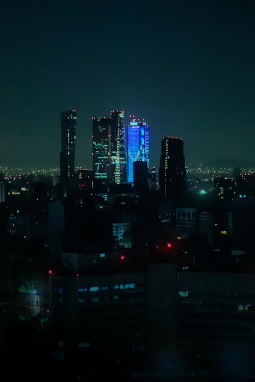 Dark Photograph of a Cityscape with Illuminated Skyscrapers at Night