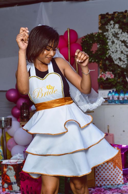 Free A woman dressed as a bride joyously dancing indoors at her vibrant bridal shower. Stock Photo