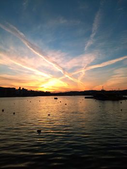 Dramatic sunset sky over Senglea harbor in Malta with reflections on the sea.