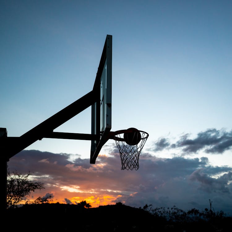 Ball Falling into the Basket in the Last Rays of the Setting Sun · Free