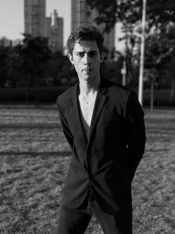 Black and White Photo of a Young Man Posing in a Park