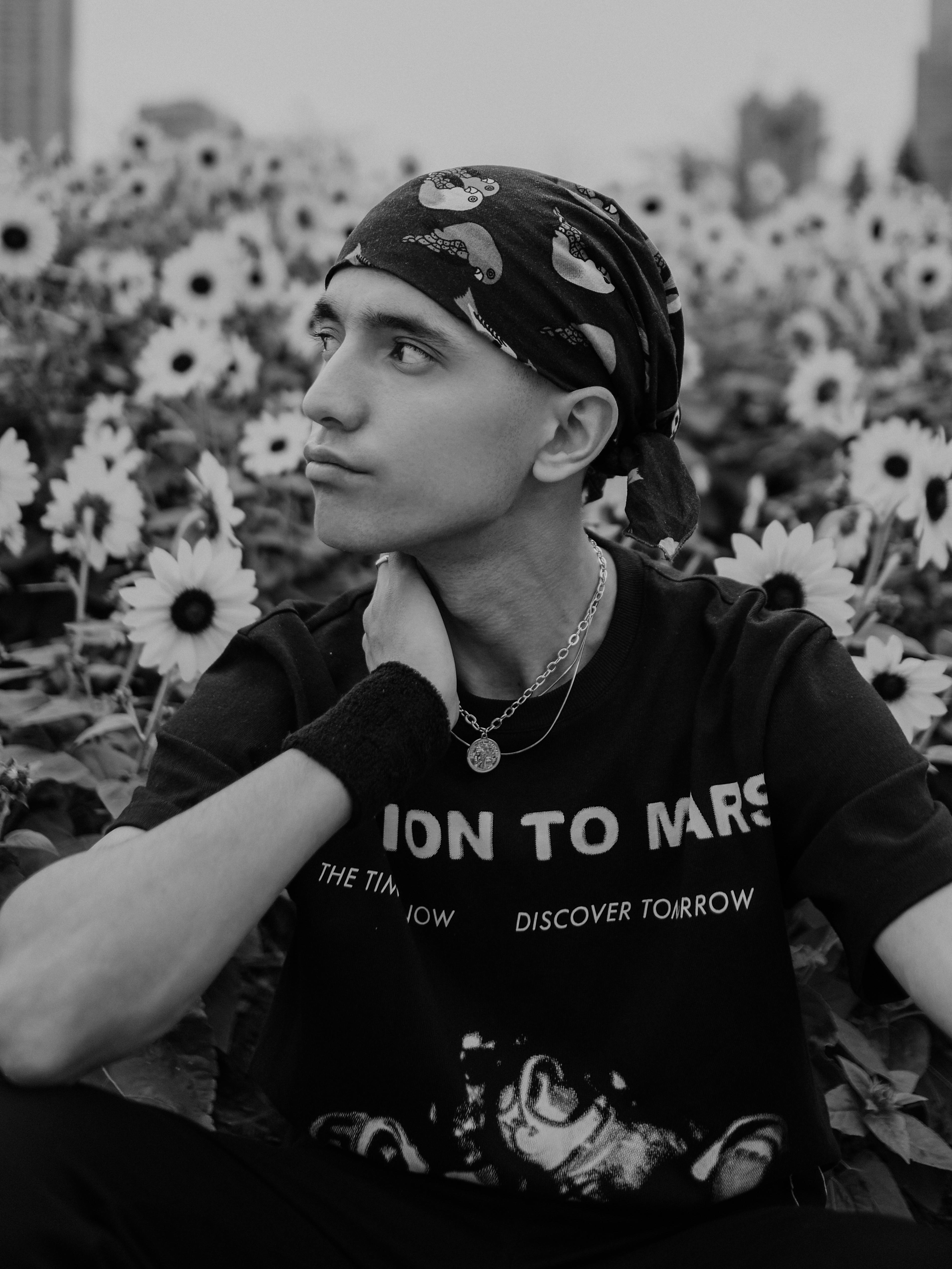 Free Stylish young man in sunflower field, bandana and t-shirt, black and white portrait. Stock Photo