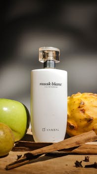 Still life of Musk Blanc Eau de Parfum with fruits and spices in a vertical shot.
